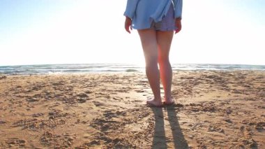 Gün batımında sahilde bir kız. Artı boyut modeli. Vücudunun tadını çıkaran ve kendini şişman sanmayan bir kız. Yaz havası.