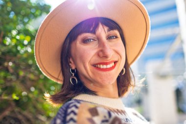 Parlak makyajlı harika bir beyaz modelin portresi. Şık şapkalı güzel bir kadın. Kameraya bakan sevimli bir kadının yakın çekimi..