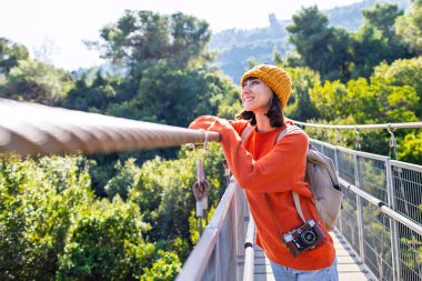 Sırt çantalı şık genç bir kadın güneşli havada seyahat eder. Yolculuğunun tadını çıkaran mutlu bir bayan turist. Sırt çantalı bir kız. seyahat ve macera.