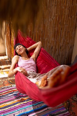 Hamakta yatan kız. Yaz tatilinin tadını çıkaran mutlu genç bir kadın. Romantik tasasız ruh hali konsepti. Yaz havası.