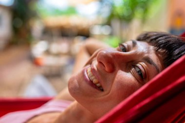 Hamakta yatan kız. Yaz tatilinin tadını çıkaran mutlu genç bir kadın. Romantik tasasız ruh hali konsepti. Yaz havası.