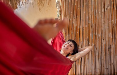 Hamakta yatan kız. Yaz tatilinin tadını çıkaran mutlu genç bir kadın. Romantik tasasız ruh hali konsepti. Yaz havası.