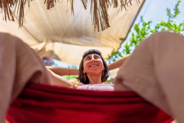 Hamakta yatan kız. Yaz tatilinin tadını çıkaran mutlu genç bir kadın. Romantik tasasız ruh hali konsepti. Yaz havası.