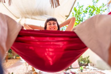 Hamakta yatan kız. Yaz tatilinin tadını çıkaran mutlu genç bir kadın. Romantik tasasız ruh hali konsepti. Yaz havası.