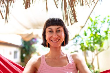 Hamakta yatan kız. Yaz tatilinin tadını çıkaran mutlu genç bir kadın. Romantik tasasız ruh hali konsepti. Yaz havası.