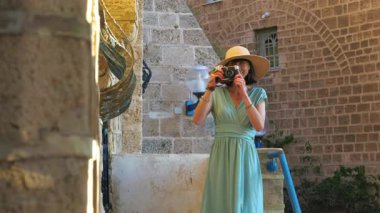 Şehirde fotoğraf çeken genç, güzel bir turist, fotoğrafçı, şehir konsepti, kameralı neşeli güzel bir kadın.