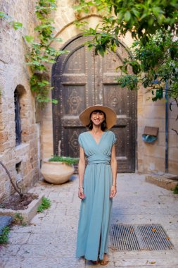 Açık havada yürüyorum. Neşeli gülümseyen stil sahibi kadın turist. Eski şehrin sokaklarında yürüyen bir gezgin. Seyahat ve tatil.