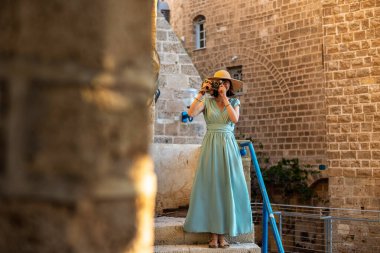 Şehirde fotoğraf çeken bir kadın fotoğrafçı. Genç bayan fotoğrafçı objektife nişan alıyor ve çekim sürecinin tadını çıkarıyor. seyahat ve içerik yaratmak. seyahat ve tatil.