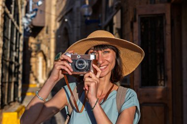 Şehirde fotoğraf çeken bir kadın fotoğrafçı. Genç bayan fotoğrafçı objektife nişan alıyor ve çekim sürecinin tadını çıkarıyor. seyahat ve içerik yaratmak. seyahat ve tatil.