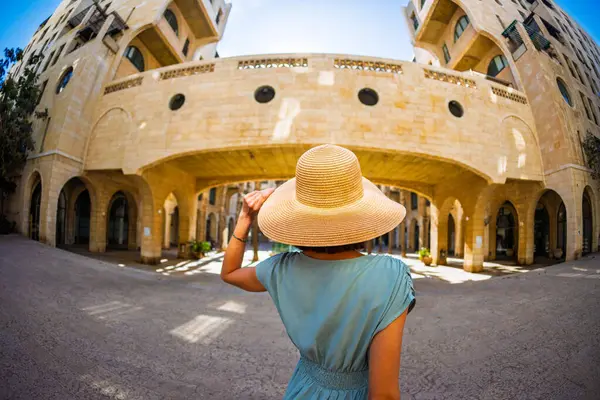 Büyüleyici görünümlü genç bir kadın eski Jaffa şehrinde güzel bir cadde boyunca yürüyor. İsrail. Seyahat ve macera.