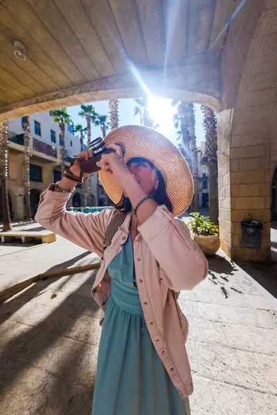 Şehirde fotoğraf çeken bir kadın fotoğrafçı. Genç bayan fotoğrafçı objektife nişan alıyor ve çekim sürecinin tadını çıkarıyor. seyahat ve içerik yaratmak. seyahat ve tatil.