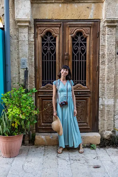 Büyüleyici görünümlü genç bir kadın eski Jaffa şehrinde güzel bir cadde boyunca yürüyor. İsrail. Seyahat ve macera.