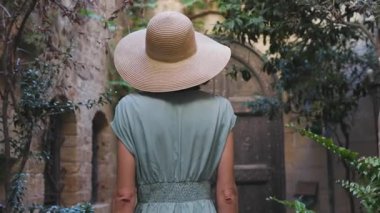 Eski şehrin dar sokaklarında yürüyen elbiseli güzel bir kız. Yaz seyahatleri ve maceralar.