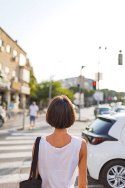 Güneşli şehir caddesinde yürüyen güzel esmer, şehir tarzı, gülümseme, yaz trendi.