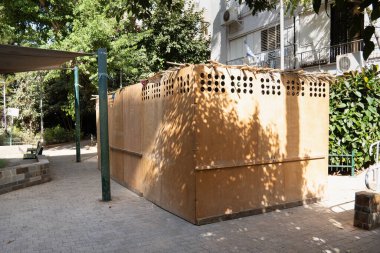 Wooden sukkah in a yard of a residential building in Israeli town Rishon Lezion during jewish holiday Sukkot clipart