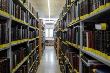 Kfar Ezion, İsrail - 24 Mayıs 2024. Yeshiva Har Ezion Kütüphanesi 'ndeki raflarda duran Yahudi dini kitapları.