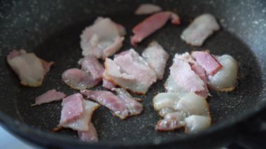 Pastırma parçaları yakın çekim mermer tavada kızartılır. 4K çözünürlük videosu.