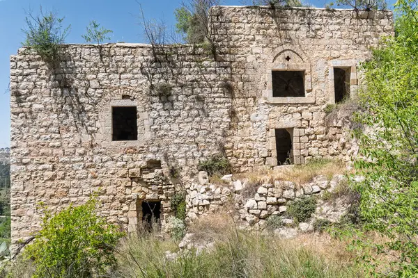 Kudüs yakınlarındaki Lifta köyünde camları olmayan ağaçlarla çevrili terk edilmiş eski bir evin duvarı.