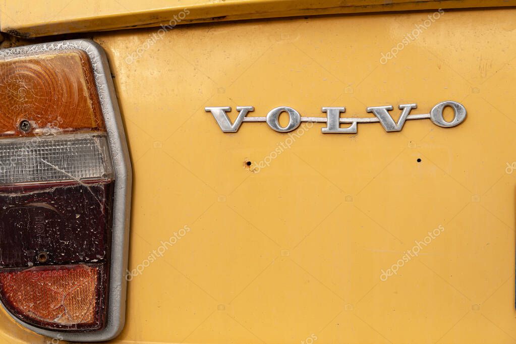 Rishon Lezion, Israel - May 15,2025. Old Volvo metallic logo emblem badge on an orange car with an old cracked car tail light