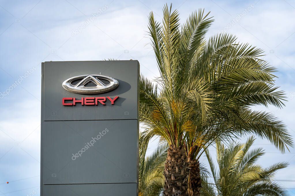 Rishon Lezion, Israel - May 15,2025. Chery Automobile dealership sign with the chrome logo with palm trees under a bright sky.