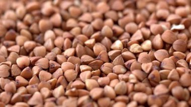 Karabuğday kahverengisi pişmemiş kuru Groats dönüşümlü makro. 4K video