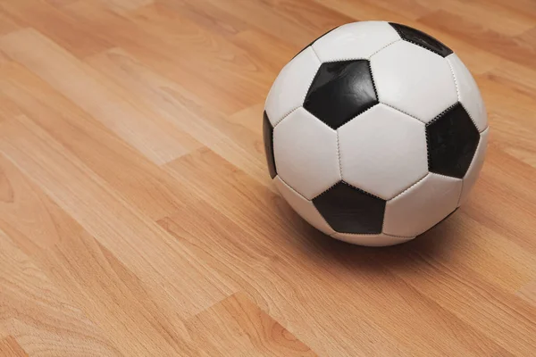 Een Wit Zwart Gekleurde Voetbal Bal Geïsoleerd Een Parketvloer — Stockfoto