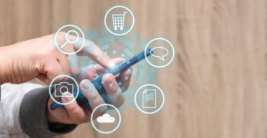 Tanımlanamayan bir kişi cep telefonunun ekranına dokunuyor ve etrafında bazı simgeler beliriyor.