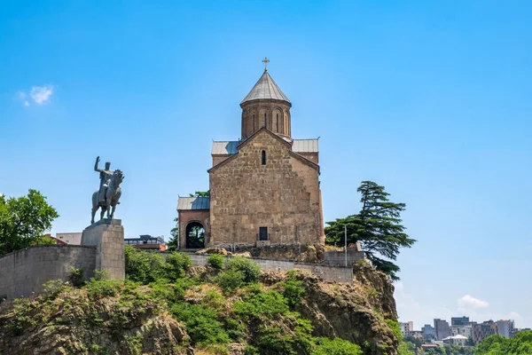 Metekhi church and monument of King Vakhtang Gorgasali on cliff in old town of Tbilisi, Georgia. Virgin Mary Assumption Church of Metekhi is Georgian Orthodox Christian church on bank of river Kura.