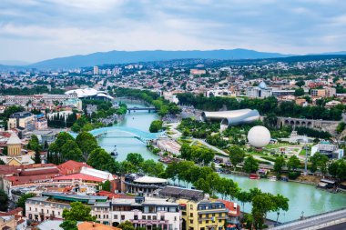 Old Tbilisi from above with Mtkvari or Kura river, bridge of peace, Rike park, hot air balloon, cable car and presidential palace. Tiflis is popular tourist destination in Georgia.