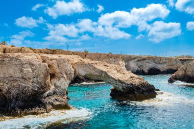 Kıbrıs 'ta Ayia Napa yakınlarında aşk köprüsü, sudan manzara. Cape Greco 'daki Doğal Kaya Köprüsü oluşumu. Agia Napa ile Cavo Greco Ulusal Parkı arasındaki kıyı şeridinde deniz mağaraları.