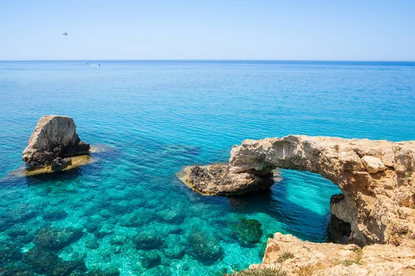 stock image Love bridge near Ayia Napa in Cyprus. Natural rock arch formation known as Bridge of Lovers at Cape Greco. Sea caves on coastline between Agia Napa and Cavo Greco National park.