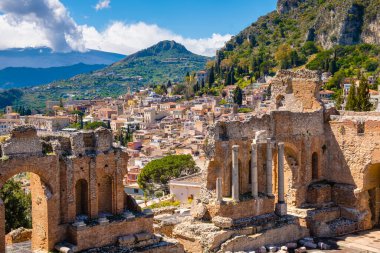 Taormina Sicilya, İtalya 'da. Eski Yunan tiyatrosunun kalıntıları, Etna Dağı bulutlarla kaplı. Taormina eski kasaba ve arka planda dağ. Sicilya 'da popüler turizm beldesi.