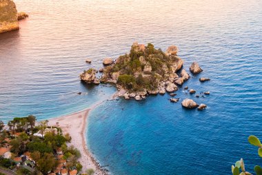 Isola Bella Taormina, Sicilya, İtalya 'da. Dar patika ve plaja bağlı küçük güzel bir adanın havadan görünüşü. Günbatımında İyon Denizi 'ndeki Sicilya kayalık kıyılarının manzarası.