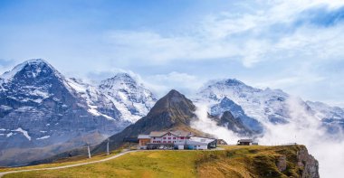 Wengen, Grindelwald ve Lauterbrunnen, İsviçre yakınlarındaki Mannlichen tepesindeki teleferik istasyonu. İsviçre Alplerinde Eiger, Monch, Jungfraujoch ve Jungfrau tepeleri olan dağ manzarası.