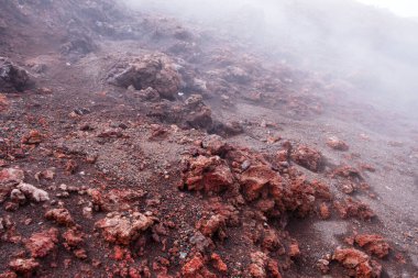 İtalya 'nın Sicilya adasındaki Etna Dağı kraterindeki kırmızı lav kayasına yakın çekim. Volkanik lav oluşumunu ve aktif volkan kraterinden çıkan dumanı ısıt..