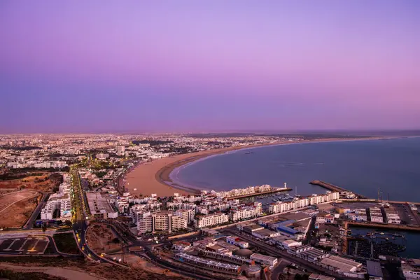 Agadir, Fas 'ta gün batımında. Güney Fas 'taki Agadir şehri ve körfezinin panoramik manzarası. Marina, Oufla ya da Kazbah kalesinden plaj ve okyanus. Afrika 'da Atlantik kıyısındaki Fas sahil beldesi.