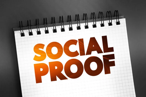 Social Proof - psychological and social phenomenon wherein people copy the actions of others in an attempt to undertake behavior in a given situation, text concept on notepad for presentations and reports
