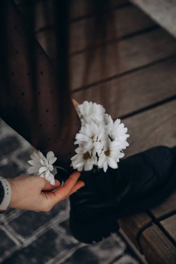 white daisies in girl's boots