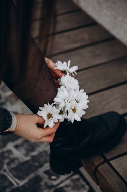 white daisies in girl's boots