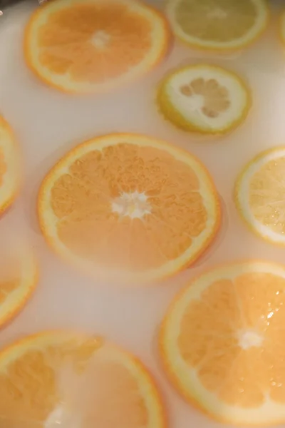 Limonlar ve portakallar sütle dolu bir kasede