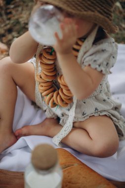 Küçük çocuk bir şişe sütle sandviç yiyor.