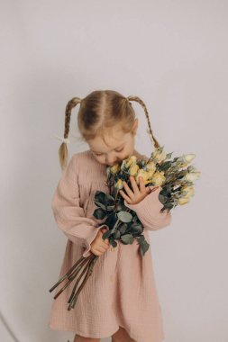 Elinde bir buket çiçekle küçük tatlı kız..