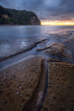 NSW Central Coast Avustralya 'daki Little Beach' te gün batımı ve uzun süre açık kalan su.