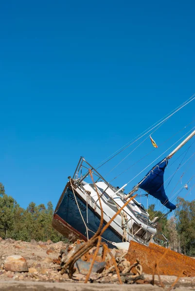 stock image sailboat stranded on land due to drought with blue sky