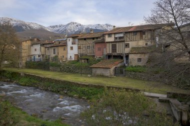 Nehrin yanındaki Yahudi mahallesinin ve arka plandaki dağların manzarası.