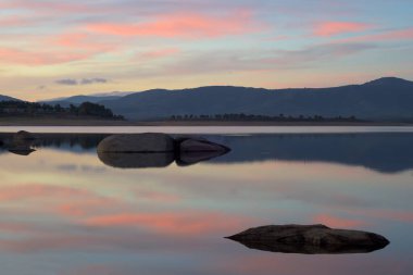 Gün batımında sakin bir bataklık Kayalar ve yumuşak renkler yatay gökyüzünde
