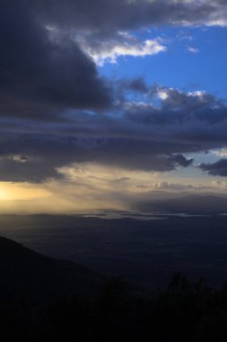 Fırtına, gün batımında gri bulutlar oluşturup suyu dikey olarak boşaltmaya başlar.