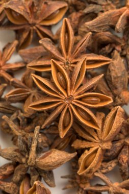 Yıldız anason kapsüllerinin yakın çekimleri doğal yıldız şekillerini ve kaba dokularını gösteriyor. Aromatik baharatlar yemek pişirmede, bitkisel aşılarda ve doğal ilaçlarda kullanılır. Yemek malzemelerini, mutfak konseptlerini ve aromatik baharatları resmetmek için mükemmel..