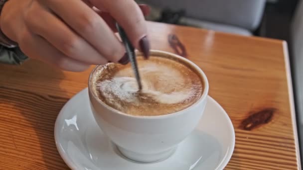 Ženská Ruka Míchá Pěnu Hrnku Kávy Lžící Kavárně Výhledem Ulici — Stock video