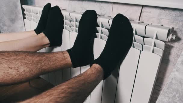 Заморожені Ноги Шкарпетках Нагріваються Опалювальному Радіаторі Біля Стіни Чоловічі Жіночі — стокове відео